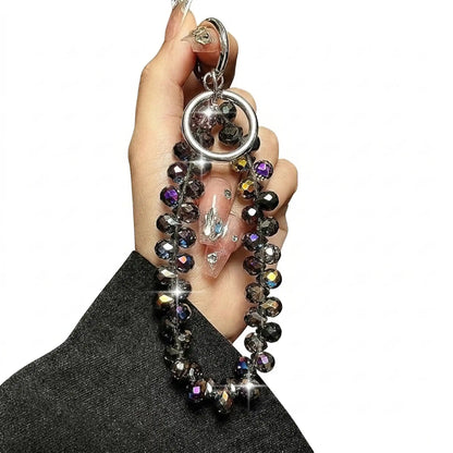 Black crystal phone charm held in hand
